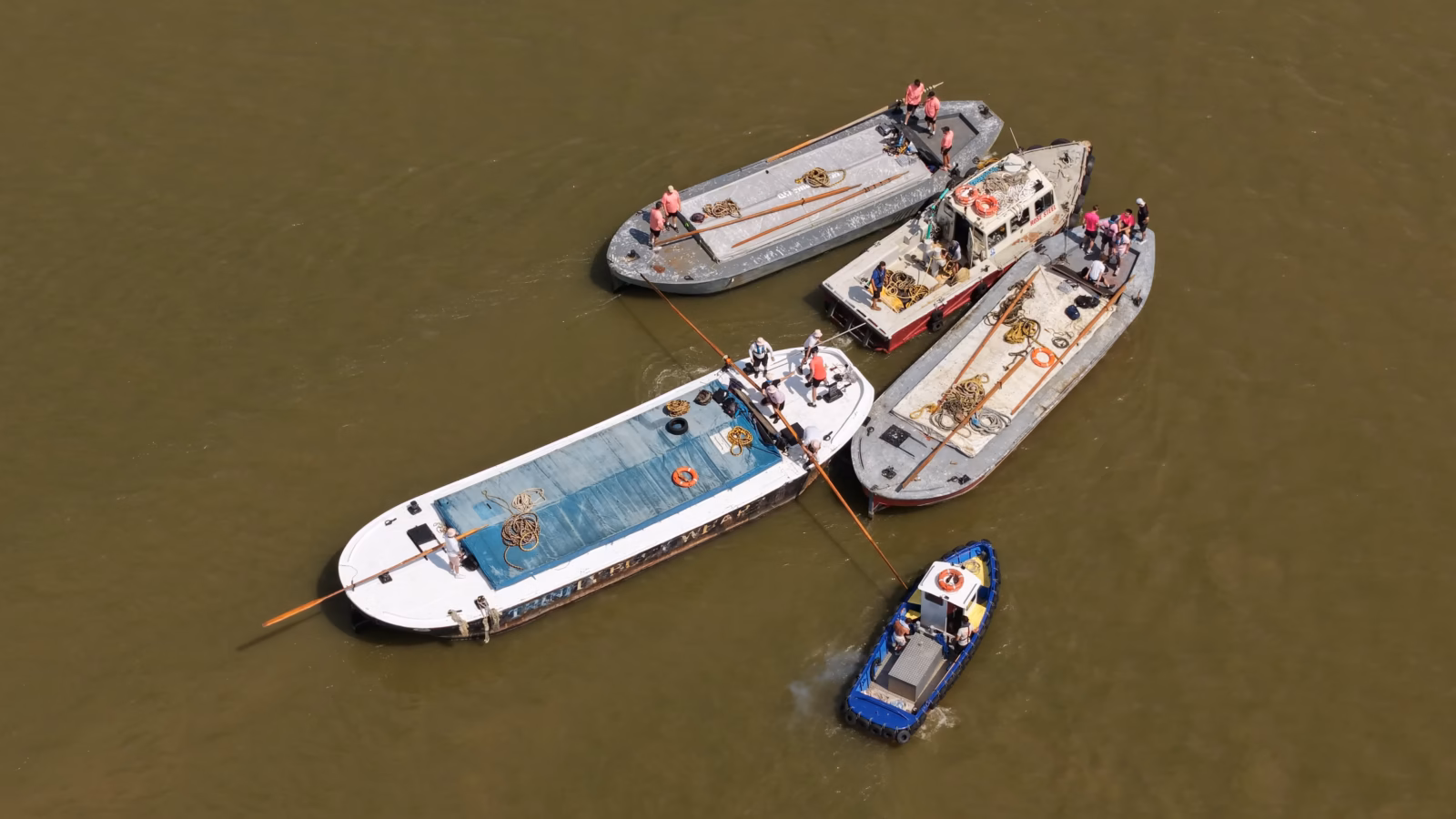 A Thames lighter under oar during the barge driving race, sweeps out over the side and a support boat standing off