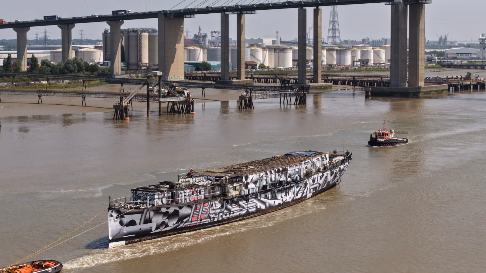 HMS President Under Tow 1 The dazzle painted hull of HMS President (1918) under tow on the River Thames, tow line made fast forward and the stripped deck visible