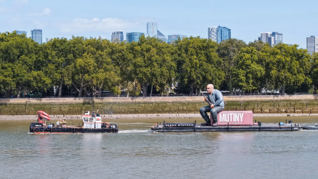 Mutiny: Jason Statham Brand Activation on the Thames 3 The tug Emilia D and the Mutiny container pontoon on the River Thames with the Canary Wharf skyline in the distance