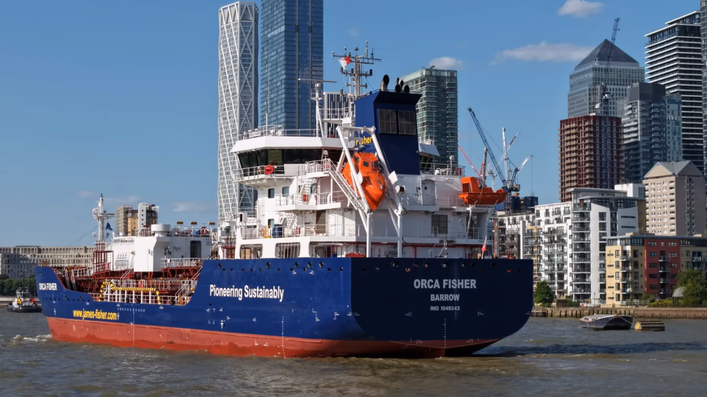 Tanker Orca Fisher with a tug in attendance on the River Thames at Canary Wharf