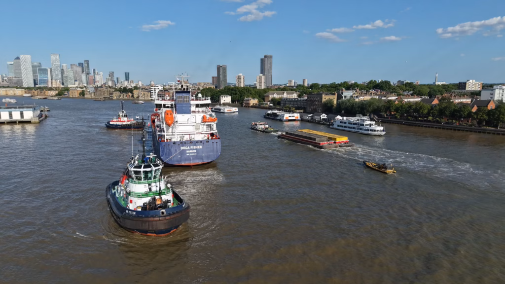The James Fisher tanker Orca Fisher moored alongside HMS Belfast at dusk with the City of London skyline behind