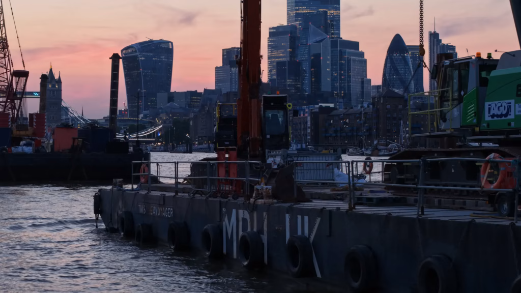 TMS Seavoyager marine plant pontoon on the River Thames at sunset with the City of London skyline
