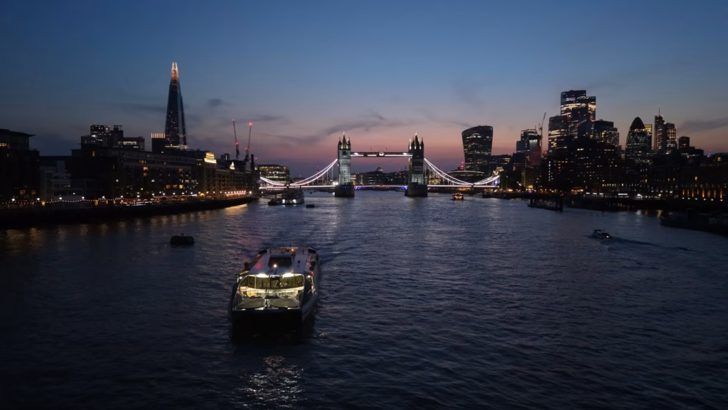 Blue hour aerial photograph of Tower Bridge and the illuminated City of London skyline