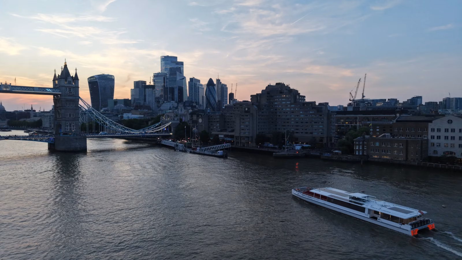 Golden hour aerial photograph of Tower Bridge and the City of London skyline over the River Thames