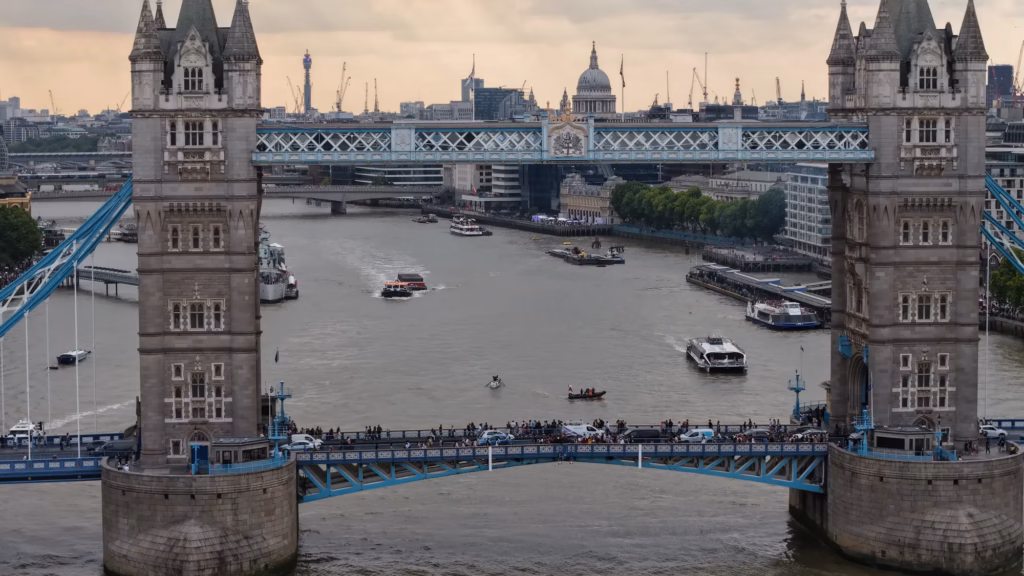 Daytime aerial view through Tower Bridge along the River Thames towards St Paul's and the City of London