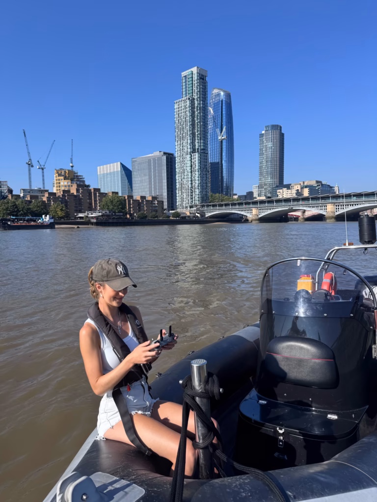 Drone operator flying from the side of our RIB on the Thames near Blackfriars Bridge, the Bankside towers behind