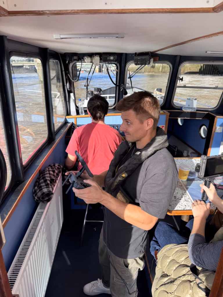 Film crew working inside the wheelhouse of a boat on the Thames, the river through the windows