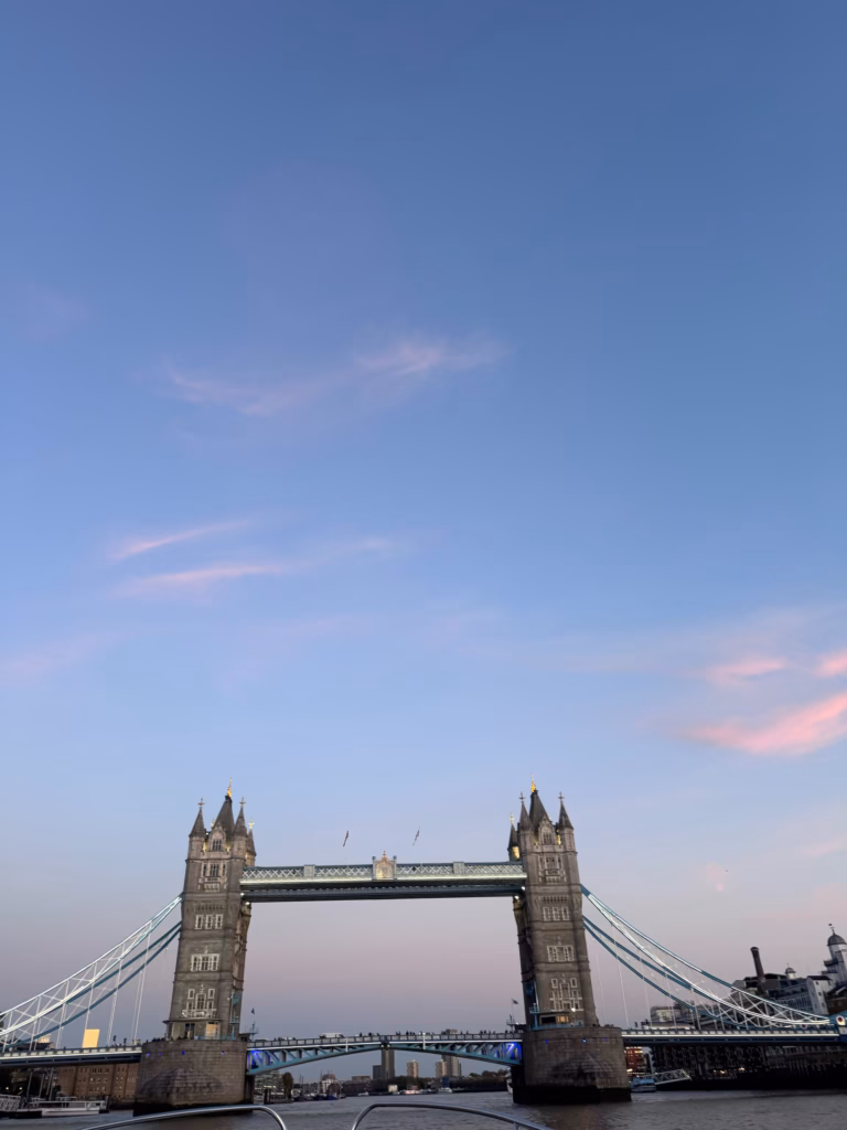 Tower Bridge at dusk from the water, under a pink and blue sky
